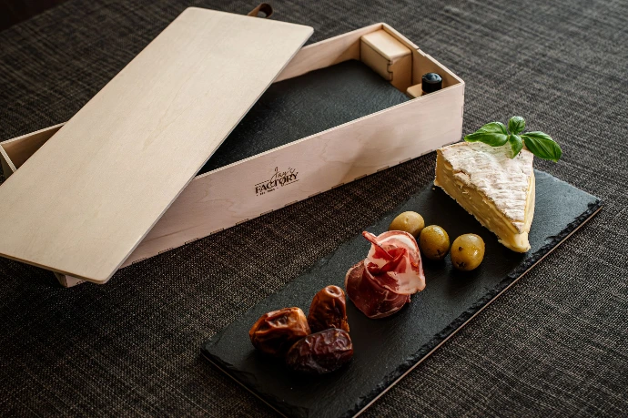 Jays Factory Schiefer-Servierplatte mit Holzunterseite und edler Holz-Geschenkbox. Stilvoll mit Antipasti und Käse angerichtet.